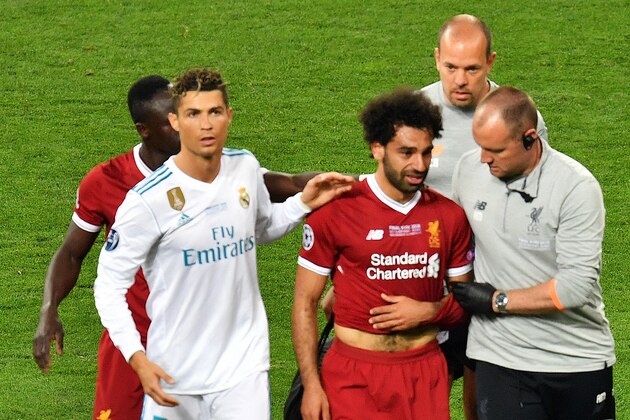 Liverpool's Egyptian forward Mohamed Salah (3rd R) is comforted by team members and Real Madrid's Portuguese forward Cristiano Ronaldo (2nd L) as he leaves the pitch after injury during the UEFA Champions League final football match between Liverpool and Real Madrid at the Olympic Stadium in Kiev, Ukraine on May 26, 2018. (Photo by Sergei SUPINSKY / AFP)        (Photo credit should read SERGEI SUPINSKY/AFP/Getty Images)