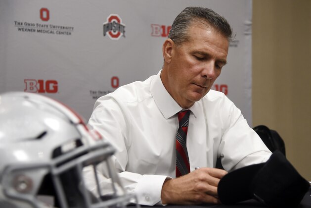 Ohio State head coach Urban Meyer autographs a hat at the Big Ten Conference NCAA college football media days in Chicago, Tuesday, July 24, 2018. (AP Photo/Annie Rice)