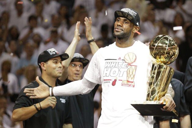The Miami Heat's LeBron James holds the the Larry O'Brien NBA Championship Trophy after Game 7 of the NBA basketball championship against the San Antonio Spurs, Friday, June 21, 2013, in Miami. The Miami Heat defeated the San Antonio Spurs 95-88 to win their second straight NBA championship. (AP Photo/Lynne Sladky)