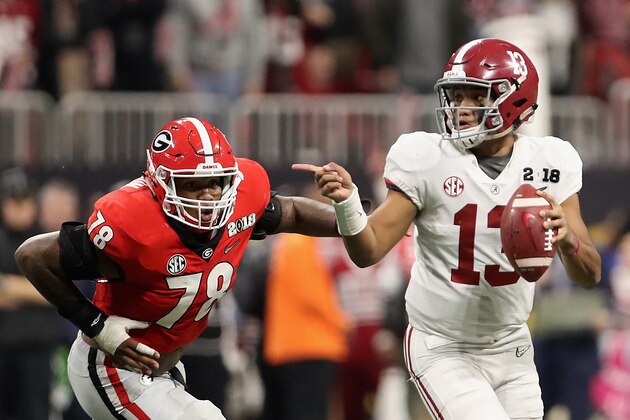 ATLANTA, GA - JANUARY 08:  Quarterback Tua Tagovailoa #13 of the Alabama Crimson Tide scrambles with the football ahead of defensive tackle Trenton Thompson #78 of the Georgia Bulldogs during the CFP National Championship presented by AT&T at Mercedes-Benz Stadium on January 8, 2018 in Atlanta, Georgia. The  Crimson Tide defeated the Bulldogs 26-23.  (Photo by Christian Petersen/Getty Images)