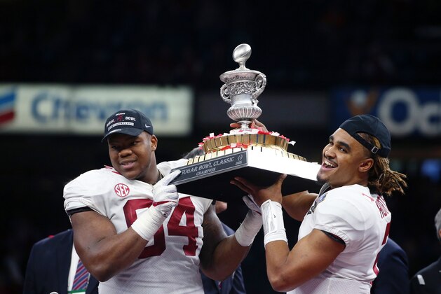 Alabama quarterback Jalen Hurts (2) and defensive lineman Da'Ron Payne (94) hoist the bowl trophy after defeating Clemson in the Sugar Bowl semi-final playoff game for the NCAA college football national championship, in New Orleans, Monday, Jan. 1, 2018. Alabama won 24-6 to advance to the national championship game. (AP Photo/Butch Dill)
