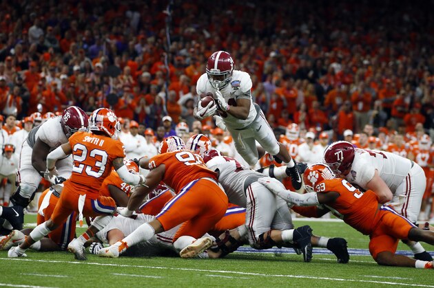 Alabama running back Damien Harris (34) dives over the pile for a first down in the second half of the Sugar Bowl semi-final playoff game against Clemson for the NCAA college football national championship, in New Orleans, Monday, Jan. 1, 2018. (AP Photo/Butch Dill)