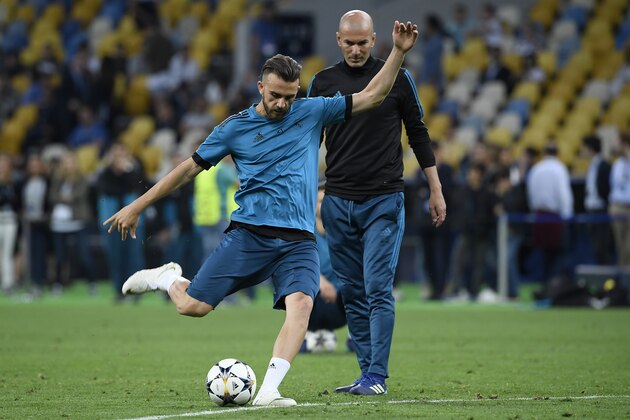 Real Madrid's Spanish forward Borja Mayoral (L) kicks the ball  next to Real Madrid's French coach Zinedine Zidane during a team's training session at the Olympic Stadium in Kiev, Ukraine on May 25, 2018, on the eve of the UEFA Champions League final football match between Liverpool and Real Madrid. (Photo by LLUIS GENE / AFP)        (Photo credit should read LLUIS GENE/AFP/Getty Images)