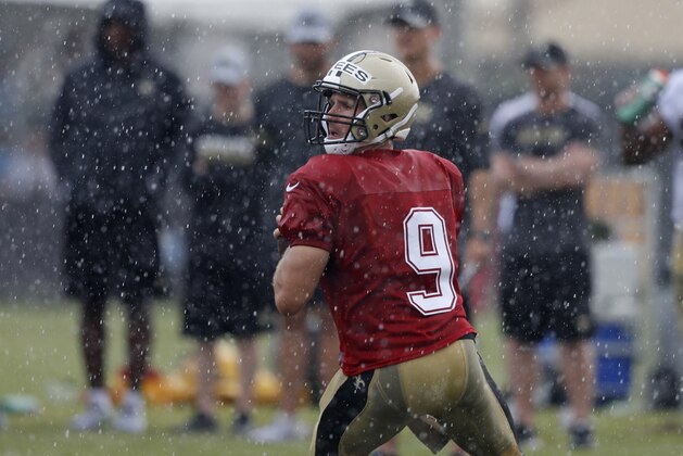 New Orleans Saints quarterback Drew Brees (9) runs through drills in the rain during training camp at their NFL football training facility in Metairie, La., Monday, July 30, 2018. (AP Photo/Gerald Herbert)