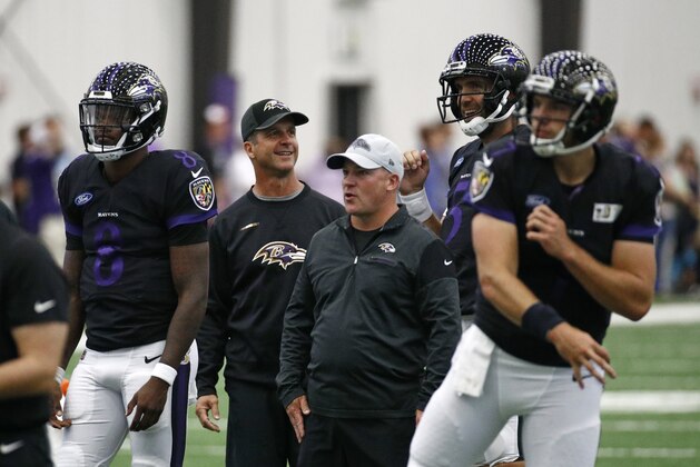 Baltimore Ravens head coach John Harbaugh, second from left, talks with quarterback Joe Flacco, second from right, during an NFL football training camp practice at the team's headquarters, Tuesday, July 24, 2018, in Owings Mills, Md. Also pictured from left are quarterback Lamar Jackson, quarterbacks coach James Urban and quarterback Josh Woodrum. (AP Photo/Patrick Semansky)