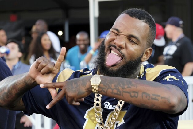 FILE - In this Aug. 20, 2016, file photo, rapper The Game flashes a sign during a preseason NFL football game between the Los Angeles Rams and the Kansas City Chiefs in Los Angeles. The Game, whose real name is Jayceon Taylor, was sentenced Monday, Feb. 6, 2017, to 120 hours of community service for assaulting an off-duty policeman during a pick-up basketball game in Hollywood. The 37-year-old rapper also received a six-month suspended jail term and was ordered to attend anger management counseling. (AP Photo/Richard Vogel, File)