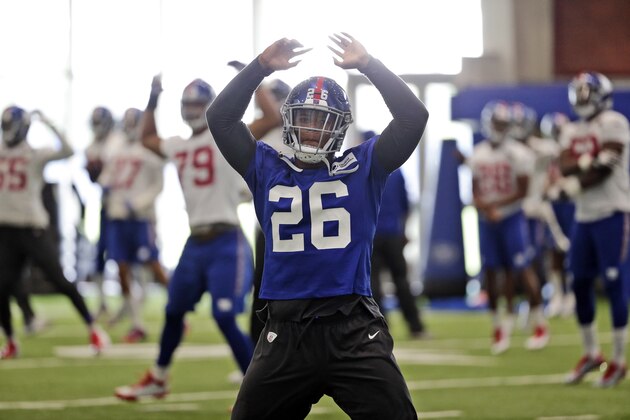 FILE - In this Monday, June 4, 2018, file photo, New York Giants' Saquon Barkley warms-up during practice at the NFL football team's training camp in East Rutherford, N.J. Speed, power, quickness, smarts, good hands. The Penn State product and No. 2 pick overall in the draft has it all. What he needs is knowledge. He has to learn a new playbook for coach Pat Shurmur and then pick up all the little adjustments that turn a college star into one of the NFL’s elite. And it has to be done in roughly four months.  (AP Photo/Seth Wenig, File)