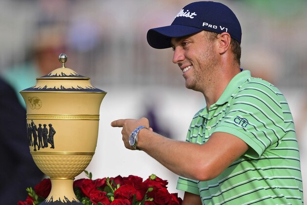 Justin Thomas points the Gary Player Cup trophy after winning the final round of the Bridgestone Invitational golf tournament at Firestone Country Club, Sunday, Aug. 5, 2018, in Akron, Ohio. (AP Photo/David Dermer)