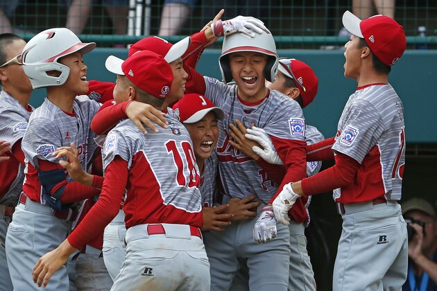 Japan's Seiya Arai, second from right, celebrates scoring the game-winning run on a single by Natsuki Yajima off Lufkin, Texas' Malcolm Deason in the fifth inning of the Little League World Series Championship baseball game in South Williamsport, Pa., Sunday, Aug. 27, 2017. Japan won 12-2 in five innings. (AP Photo/Gene J. Puskar).
