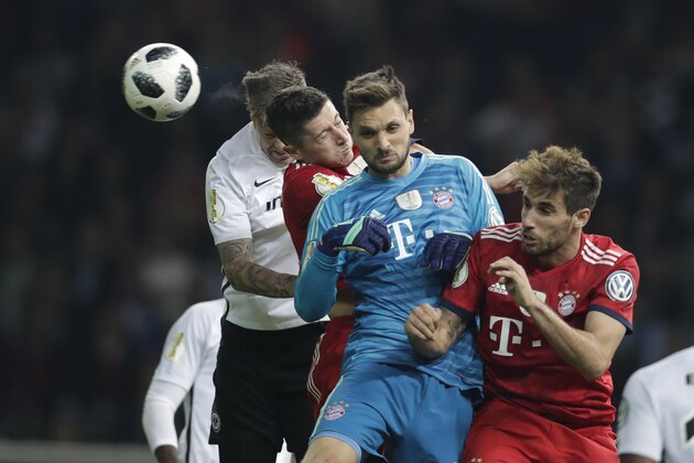 Bayern goalkeeper Sven Ulreich, foreground, Bayern's Javi Martinez, right, and Bayern's Robert Lewandowski go for a header during the German soccer cup final match between FC Bayern Munich and Eintracht Frankfurt in Berlin, Germany, Saturday, May 19, 2018. (AP Photo/Michael Sohn)