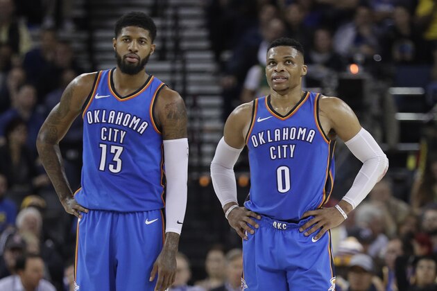 Oklahoma City Thunder's Russell Westbrook (0) stands next to teammate Paul George (13) during the first half of an NBA basketball game against the Golden State Warriors Tuesday, Feb. 6, 2018, in Oakland, Calif. (AP Photo/Marcio Jose Sanchez)