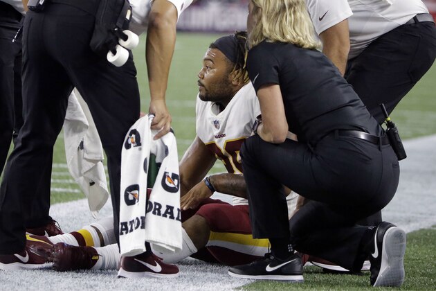 Washington Redskins running back Derrius Guice, center, receives attention on the field after an injury during the first half of a preseason NFL football game against the New England Patriots, Thursday, Aug. 9, 2018, in Foxborough, Mass. (AP Photo/Steven Senne)