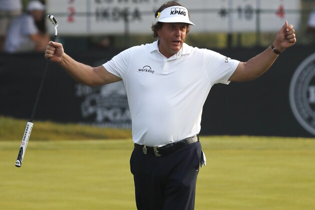 Phil Mickelson talks with the crown before resuming the second round of the PGA Championship golf tournament at Bellerive Country Club, Saturday, Aug. 11, 2018, in St. Louis. (AP Photo/Jeff Roberson)