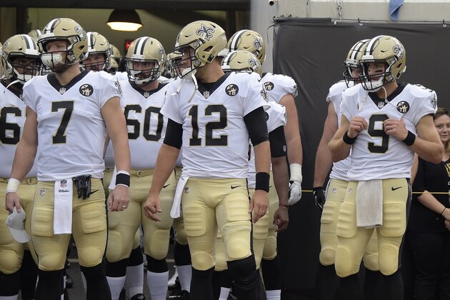 New Orleans Saints quarterback Taysom Hill (7), quarterback Tom Savage (12) and quarterback Drew Brees (9) wait to run onto the field during team introductions before an NFL preseason football game against the Jacksonville Jaguars Thursday, Aug. 9, 2018, in Jacksonville, Fla. (AP Photo/Phelan M. Ebenhack)