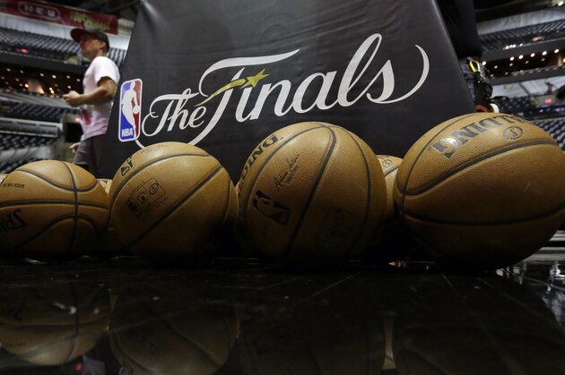 NBA basketballs and the NBA Finals logo are seen on the court prior to Game 1 of the NBA Finals basketball series between the San Antonio Spurs and Miami Heat, Thursday, June 5, 2014, in San Antonio. (AP Photo/Eric Gay)