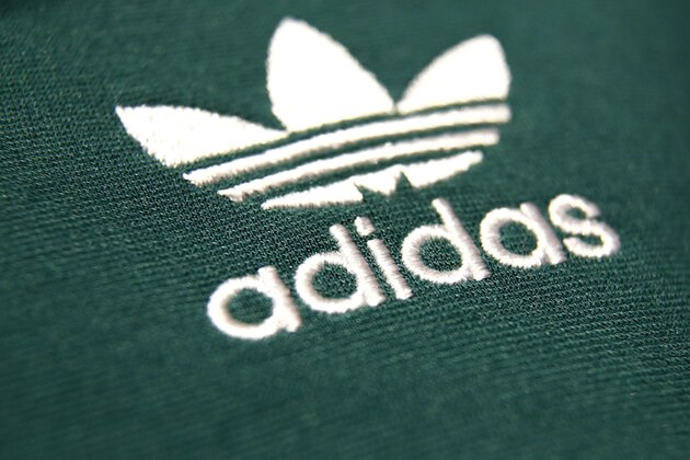 The logo of German sports equipment company adidas AG is printed on a shirt during the annual balance news conference in Herzogenaurach, Germany, Wednesday, March 14, 2018. (AP Photo/Matthias Schrader)