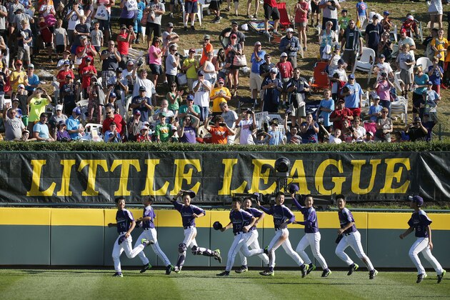 The South Korea team takes a victory lap around the warning track at Howard J. Lamade Stadium while celebrating an 8-4 win over Chicago in the Little League World Series championship baseball game against Chicago in South Williamsport, Pa., Sunday, Aug. 24, 2014. (AP Photo/Gene J. Puskar)