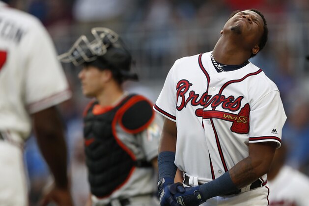 Atlanta Braves' Ronald Acuna Jr., right, reacts after being hit by a pitch from Miami Marlins'Jose Urena during the first inning of a baseball game Wednesday , Aug. 15, 2018 in Atlanta. Both dugouts emptied and Urena was ejected. Marlins catcher J.T. Realmuto is at rear. (AP Photo/John Bazemore)