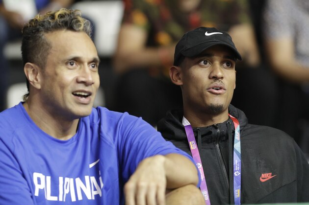 Filipino-American NBA player Jordan Clarkson, right, watches with Philippines' Pauliasi Taulava on the bench as he arrives during a match against Philippines and Kazakhstan at the men's basketball match at the 18th Asian Games in Jakarta, Indonesia on Thursday, Aug. 16, 2018. Clarkson will play with the Philippine team on the next games. (AP Photo/Aaron Favila)
