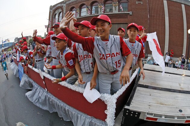 The Japan Region Champion Little League team from Kawaguchi, Japan rides in the Little League Grand Slam Parade in downtown Williamsport, Pa.,Wednesday, Aug. 15, 2018. (AP Photo/Gene J. Puskar).