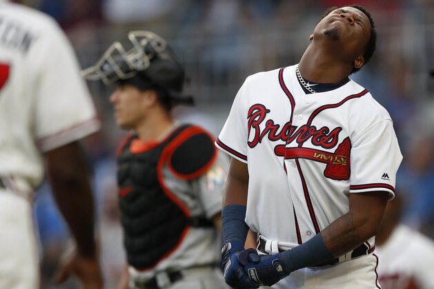 Atlanta Braves' Ronald Acuna Jr., right, reacts after being hit by a pitch from Miami Marlins'Jose Urena during the first inning of a baseball game Wednesday , Aug. 15, 2018 in Atlanta. Both dugouts emptied and Urena was ejected. Marlins catcher J.T. Realmuto is at rear. (AP Photo/John Bazemore)