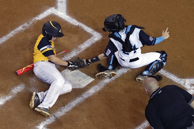 Peachtree City, Ga.'s Jack Ryan, left, avoids the tag by Coeur d'Alene, Idaho, catcher Avery Cherry to score during the second inning of a Little League World Series baseball game in South Williamsport, Pa., Saturday, Aug. 18, 2018. Georgia won 3-0, eliminating Idaho. (AP Photo/Gene J. Puskar)