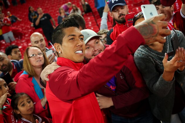 LIVERPOOL, ENGLAND - AUGUST 07: Roberto Firmino of Liverpool has a selfie with a fan during the pre-season friendly between Liverpool and Torino at Anfield on August 7, 2018 in Liverpool, England. (Photo by Robbie Jay Barratt - AMA/Getty Images)