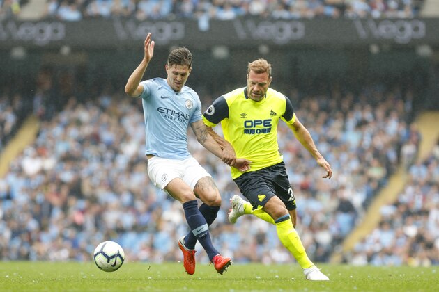 MANCHESTER, ENGLAND - AUGUST 19:      Laurent Depoitre of Huddersfield Town battles with John Stones of Manchester City during the Premier League match between Manchester City and Huddersfield Town at Etihad Stadium on August 19, 2018 in Manchester, United Kingdom. (Photo by John Early/Getty Images)
