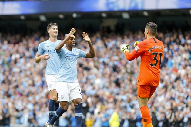 MANCHESTER, ENGLAND - AUGUST 19:     Fernandinho of Manchester City and John Stones of Manchester City celebrate with Ederson, goalkeeper of Manchester City after the keeper's pass to set up a City goal during the Premier League match between Manchester City and Huddersfield Town at Etihad Stadium on August 19, 2018 in Manchester, United Kingdom. (Photo by John Early/Getty Images)