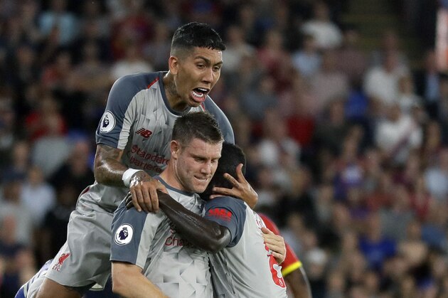 Liverpool's James Milner, center front, celebrates with teammates after scoring his side's opening goal from penalty during the English Premier League soccer match between Crystal Palace and Liverpool at Selhurst Park stadium in London, Monday, Aug. 20, 2018. (AP Photo/Kirsty Wigglesworth)