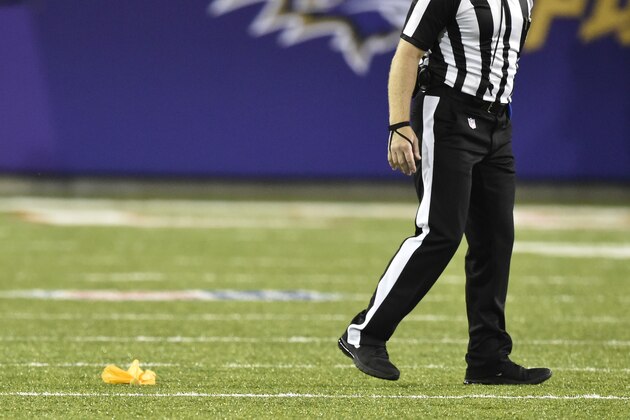 An NFL referee walks beside a penalty flag during the Pro Football Hall of Fame NFL preseason game between the Chicago Bears and the Baltimore Ravens Thursday, Aug. 2, 2018, in Canton, Ohio. The Ravens won 17-16. (AP Photo/David Richard)