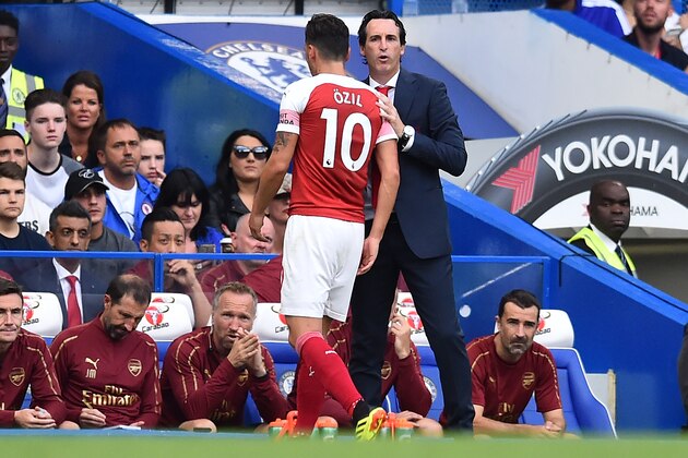 Arsenal's Spanish head coach Unai Emery (R) gestures to Arsenal's German midfielder Mesut Ozil as he is substituted during the English Premier League football match between Chelsea and Arsenal at Stamford Bridge in London on August 18, 2018. (Photo by Glyn KIRK / AFP) / RESTRICTED TO EDITORIAL USE. No use with unauthorized audio, video, data, fixture lists, club/league logos or 'live' services. Online in-match use limited to 120 images. An additional 40 images may be used in extra time. No video emulation. Social media in-match use limited to 120 images. An additional 40 images may be used in extra time. No use in betting publications, games or single club/league/player publications. /         (Photo credit should read GLYN KIRK/AFP/Getty Images)