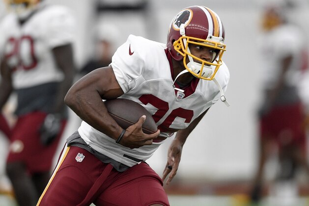 Washington Redskins running back Adrian Peterson runs with the ball during an NFL football team practice, Tuesday, Aug. 21, 2018, in Ashburn, Va. (AP Photo/Nick Wass)