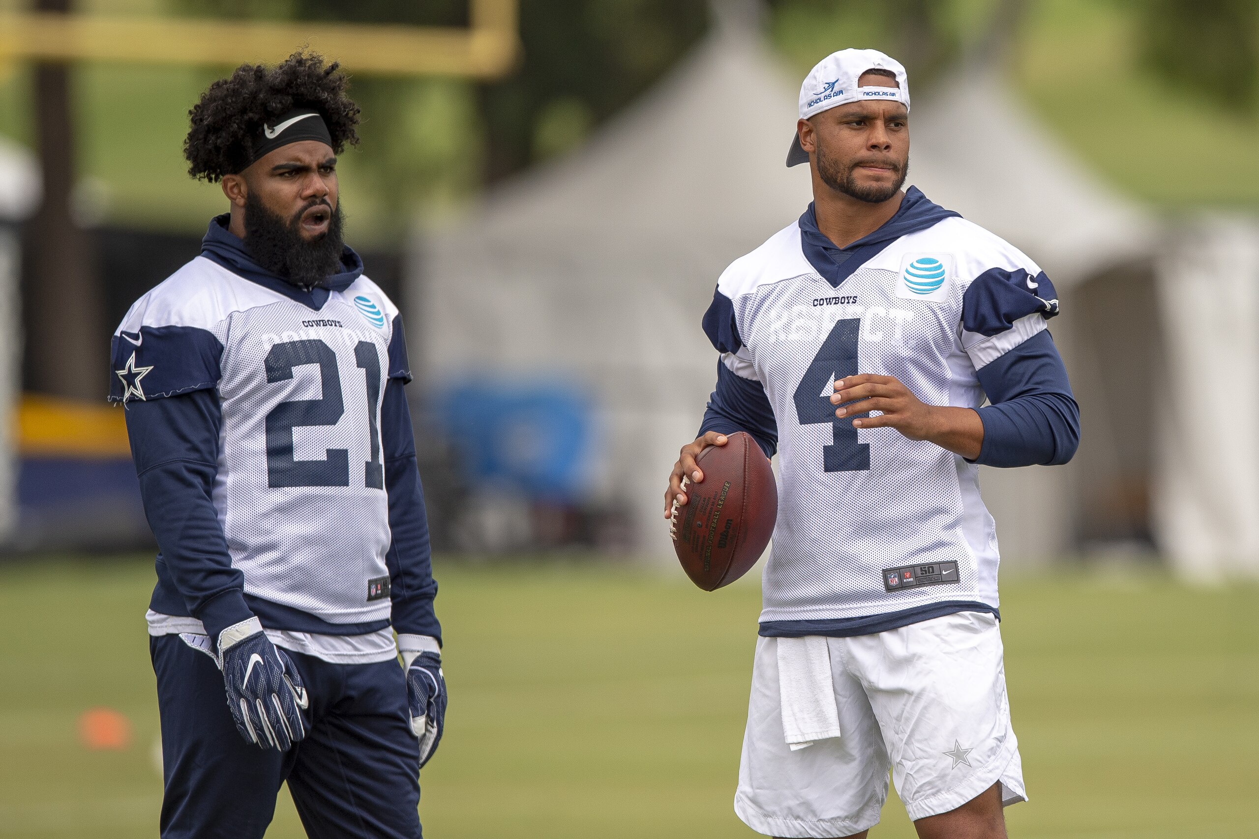 Dallas Cowboys running back Ezekiel Elliott (21) and quarterback Dak Prescott (4) run plays during their NFL football training camp, Thursday, July 26, 2018, in Oxnard, Calif. (AP Photo/Gus Ruelas)