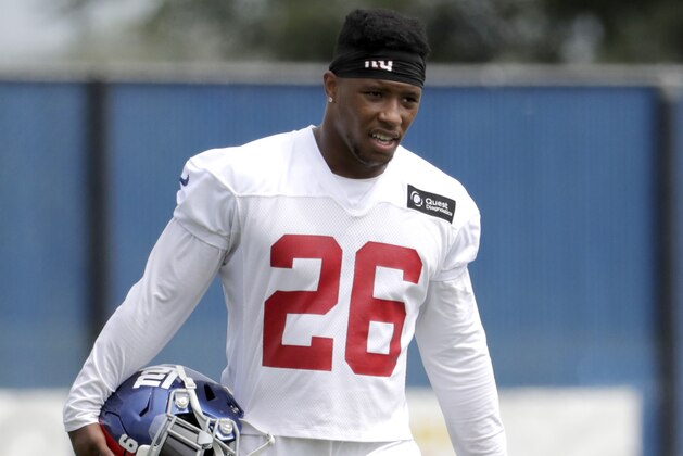 New York Giants running back Saquon Barkley works out on his own while teammates work out together during NFL football training camp, Tuesday, Aug. 21, 2018, in East Rutherford, N.J. (AP Photo/Julio Cortez)