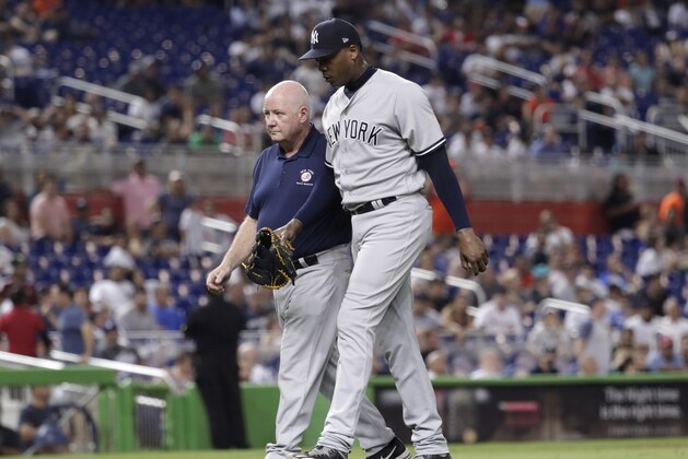 New York Yankees relief pitcher Aroldis Chapman, right, leaves the game with an injury during the twelfth inning of a baseball game against the Miami Marlins, Tuesday, Aug. 21, 2018, in Miami. The Yankees won 2-1 in twelve innings. (AP Photo/Lynne Sladky)