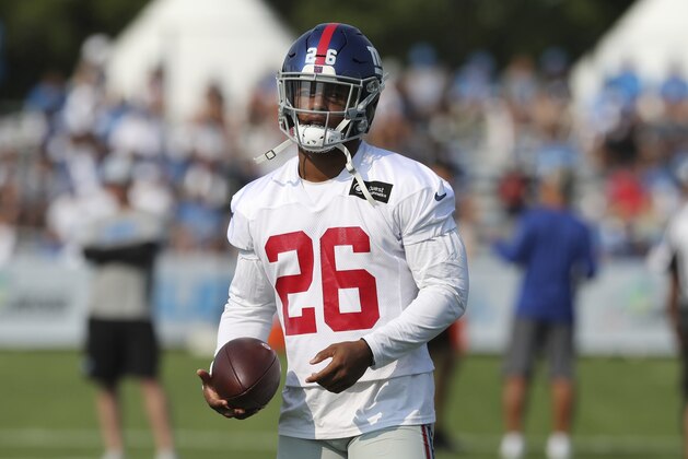 New York Giants running back Saquon Barkley walks through a drill on the field at the Detroit Lions football training facility, Tuesday, Aug. 14, 2018, in Allen Park, Mich. (AP Photo/Carlos Osorio)