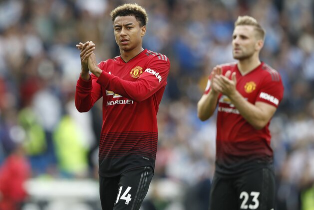 Manchester United's Jesse Lingard, left, and Luke Shaw applaud supporters as they leave the pitch after the English Premier League soccer match between Brighton and Hove Albion and Manchester United at the Amex stadium in Brighton, England, Sunday, Aug. 19, 2018. Brighton won the match 3-2. (AP Photo/Alastair Grant)