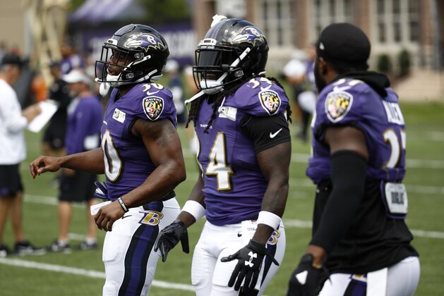 Baltimore Ravens running backs Kenneth Dixon, from left, Alex Collins and Javorius Allen warm up at the start of a joint NFL football training camp practice with the Los Angeles Rams at the Raven's headquarters, Tuesday, Aug. 7, 2018, in Owings Mills, Md. (AP Photo/Patrick Semansky)