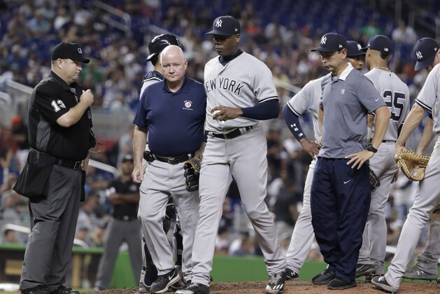 New York Yankees relief pitcher Aroldis Chapman, center, leaves the game due to an injury in the twelfth inning of a baseball game against the Miami Marlins, Tuesday, Aug. 21, 2018, in Miami. The Yankees won 2-1 in twelve innings. (AP Photo/Lynne Sladky)