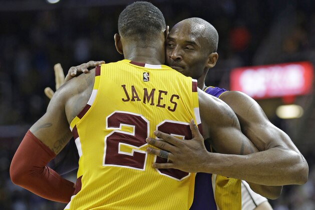 Los Angeles Lakers' Kobe Bryant, back, hugs Cleveland Cavaliers' LeBron James as Bryant leaves the game in the second half of an NBA basketball game Wednesday, Feb. 10, 2016, in Cleveland. (AP Photo/Tony Dejak)