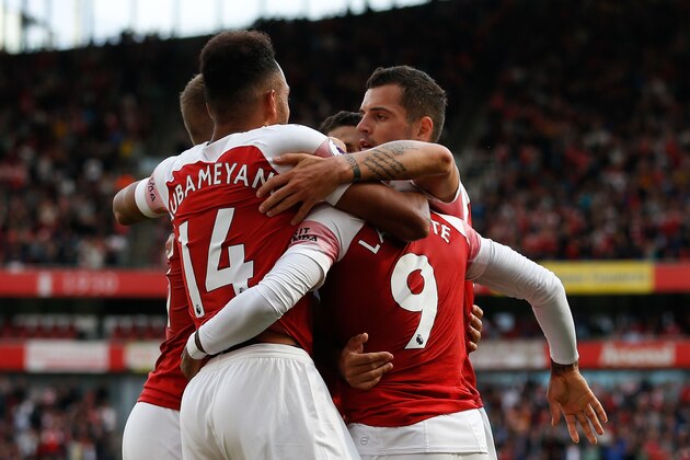 Arsenal players celebrate with Arsenal's French striker Alexandre Lacazette (R) after an own goal from a Lacazette cross gave Arsenal their second goal during the English Premier League football match between Arsenal and West Ham United at the Emirates Stadium in London on August 25, 2018. (Photo by Ian KINGTON / AFP) / RESTRICTED TO EDITORIAL USE. No use with unauthorized audio, video, data, fixture lists, club/league logos or 'live' services. Online in-match use limited to 120 images. An additional 40 images may be used in extra time. No video emulation. Social media in-match use limited to 120 images. An additional 40 images may be used in extra time. No use in betting publications, games or single club/league/player publications. /         (Photo credit should read IAN KINGTON/AFP/Getty Images)