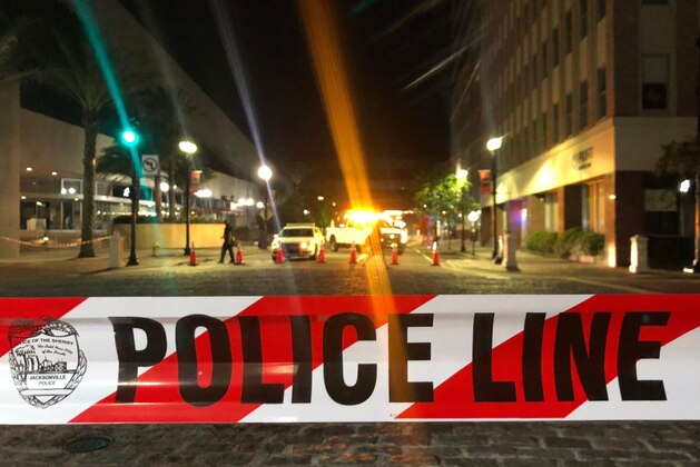 This photo shows a police car behind police tape blocking a street leading to the Jacksonville Landing area in downtown Jacksonville, Florida, August 26, 2018, where three people were killed, including the gunman, and 11 others wounded. - Two people were killed and 11 others wounded on August 26 when a video game tournament competitor went on a shooting rampage before turning the gun on himself in the northern Florida city of Jacksonville, local police said. Sheriff Mike Williams named the suspect of the shooting at a Madden 19 American football eSports tournament as 24-year-old David Katz from Baltimore, Maryland. (Photo by Gianrigo MARLETTA / AFP)        (Photo credit should read GIANRIGO MARLETTA/AFP/Getty Images)