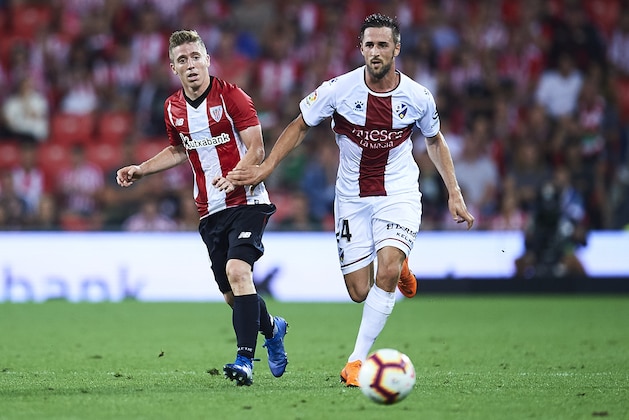 BILBAO, SPAIN - AUGUST 27:  Iker Muniain of Athletic Club (L) competes for the ball with Jorge Miramon of SD Huesca (R) during the La Liga match between Athletic Club and SD Huesca at San Mames Stadium on August 27, 2018 in Bilbao, Spain.  (Photo by Juan Manuel Serrano Arce/Getty Images)