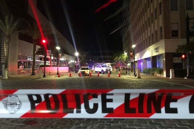 TOPSHOT - This photo shows a police car behind police tape blocking a street leading to the Jacksonville Landing area in downtown Jacksonville, Florida, August 26, 2018, where three people were killed, including the gunman, and 11 others wounded. - Two people were killed and 11 others wounded on August 26 when a video game tournament competitor went on a shooting rampage before turning the gun on himself in the northern Florida city of Jacksonville, local police said. Sheriff Mike Williams named the suspect of the shooting at a Madden 19 American football eSports tournament as 24-year-old David Katz from Baltimore, Maryland. (Photo by Gianrigo MARLETTA / AFP)        (Photo credit should read GIANRIGO MARLETTA/AFP/Getty Images)
