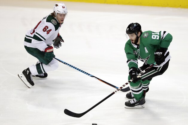 Minnesota Wild's Mikael Granlund (64) defends as Dallas Stars center Tyler Seguin (91) handles the puck in the third period of an NHL hockey game in Dallas, Saturday, March 31, 2018. (AP Photo/Tony Gutierrez)