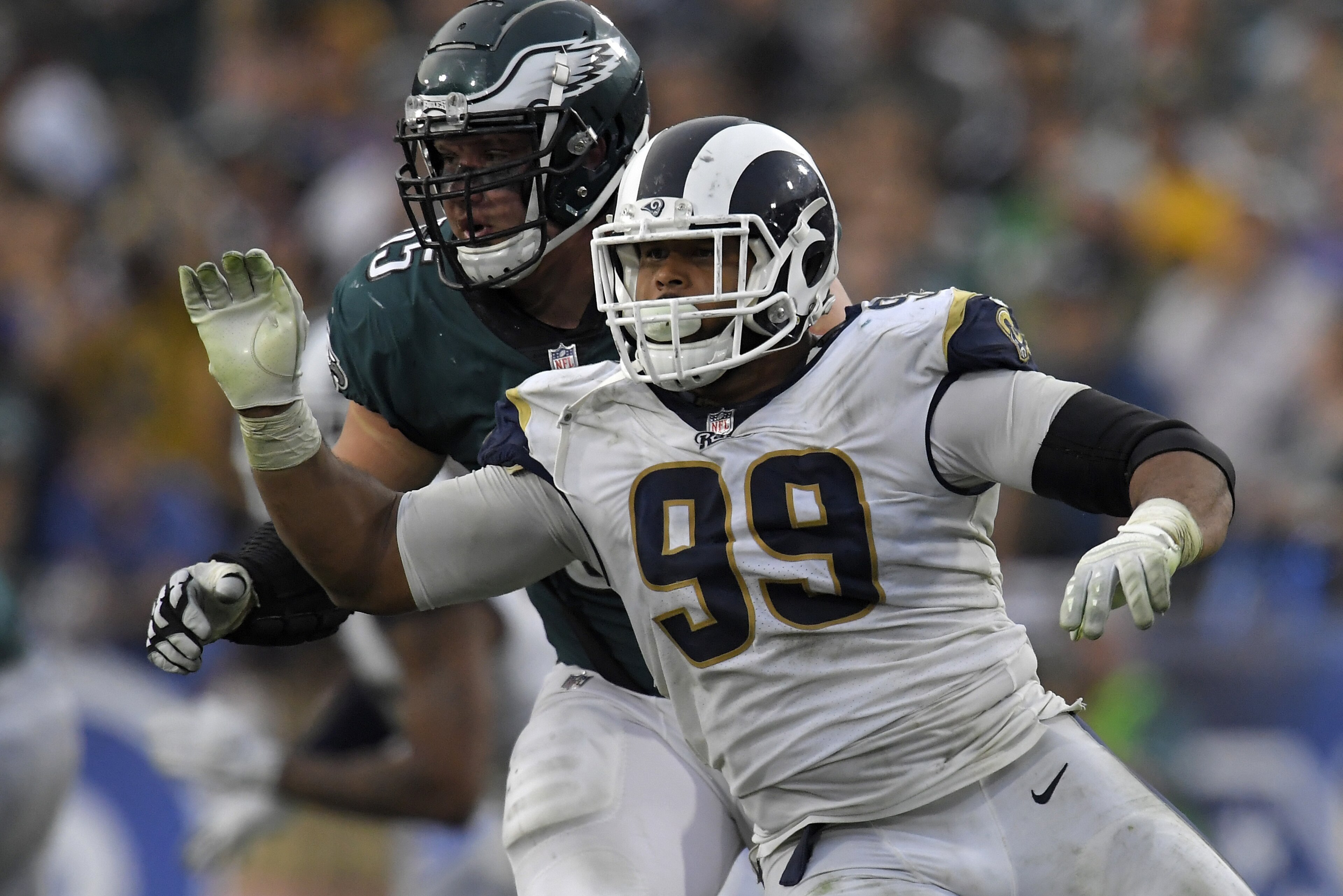 FILE - In this Dec. 10, 2017, file photo, Los Angeles Rams defensive end Aaron Donald, right, gets past Philadelphia Eagles offensive tackle Lane Johnson during an NFL football game in Los Angeles. Donald is not attending the Rams' mandatory minicamp while he continues his lengthy quest for a lucrative new contract. Donald wasn't on the field with his teammates for the Rams' first minicamp workout Tuesday, June 12, 2018. and he wasn't at their training complex for their off-field commitments Monday, either. The NFL Defensive Player of the Year also skipped the Rams' voluntary workout program over the previous two months. (AP Photo/Mark J. Terrill, File)
