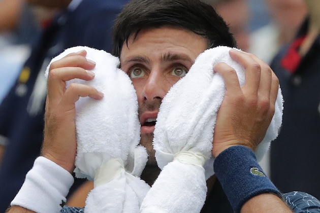 Novak Djokovic, of Serbia, puts an ice towel to his face during a changeover in his match against Marton Fucsovics, of Hungary, during the first round of the U.S. Open tennis tournament, Tuesday, Aug. 28, 2018, in New York. (AP Photo/Frank Franklin II)