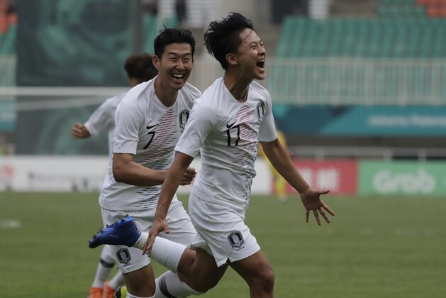 South Korea's Lee Seung-woo celebrates his goal with teammate Son Heung-min after scoring during their men's semifinal soccer match against Vietnam at the 18th Asian Games in Bogor, West Java, Indonesia, Wednesday, Aug. 29, 2018. (AP Photo/Lee Jin-man)