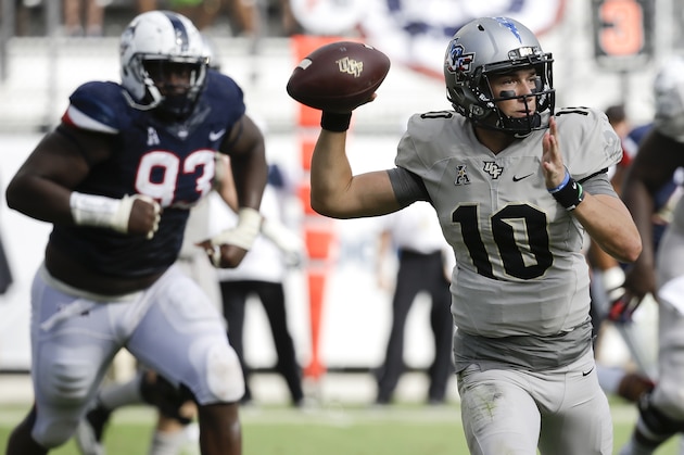Central Florida quarterback McKenzie Milton (10) looks for a receiver as he is pressured by Connecticut defensive lineman Folorunso Fatukasi (93) during the second half of an NCAA college football game, Saturday, Nov. 11, 2017, in Orlando, Fla. Central Florida won 49-24. (AP Photo/John Raoux)